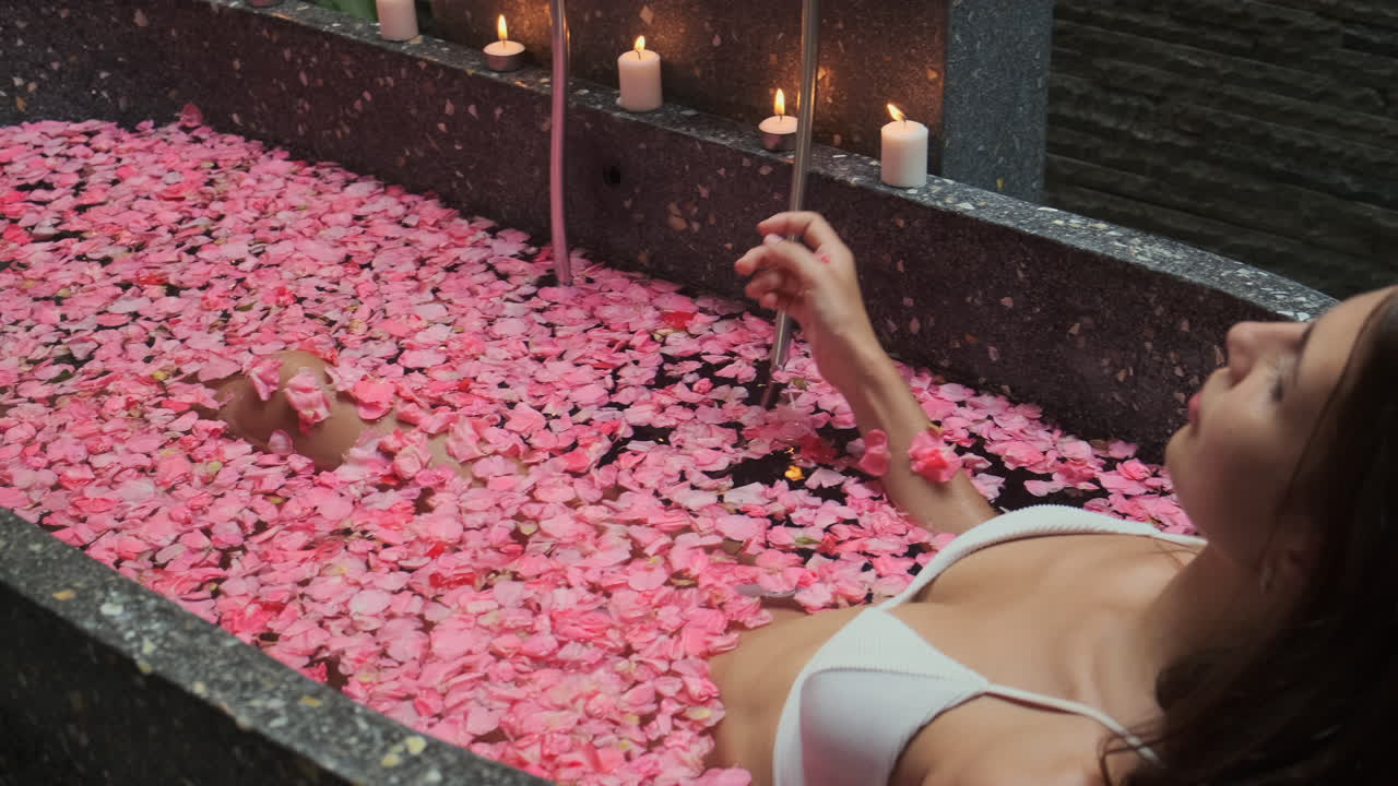 женщина отдыхает в ванне с розовыми лепестками