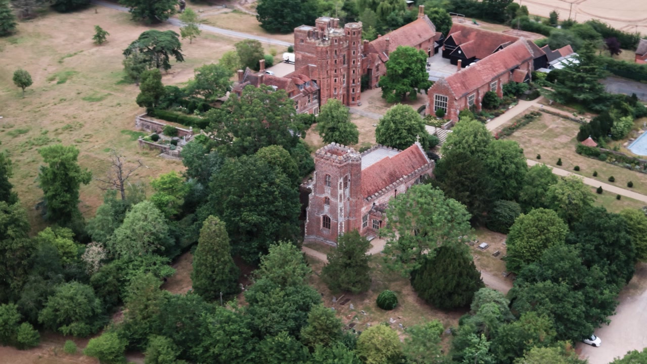 Et autentisk luftperspektiv av det historiske Layer Marney Tower og den omkringliggende eiendommen i Essex, Storbritannia. Viser Tudor-arkitektur og frodig grøntområde for reise- og kulturarvsinnhold.