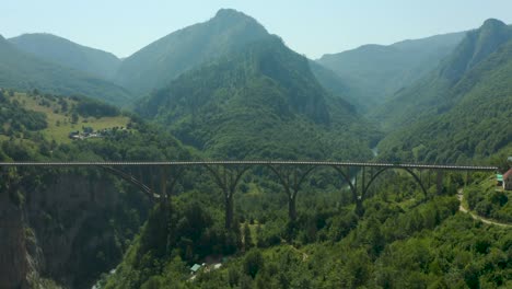 drone footage of arched bridge of djurdjevic in mountain of montenegro over the tara river