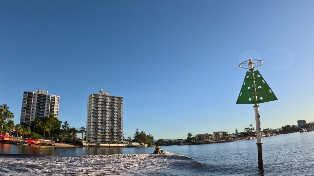 건물과 물 표지판 근처에 이동하는 제트 스키