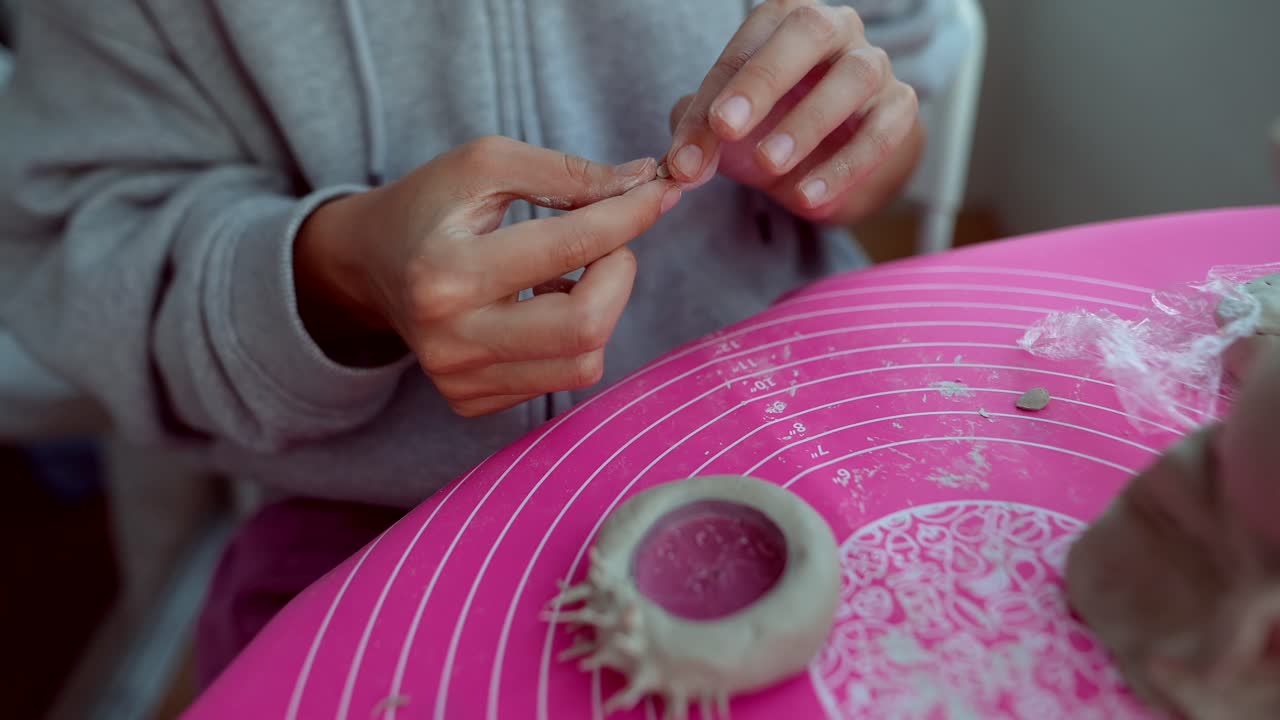 Primo piano di mani che modellano l'argilla in una piccola scultura
