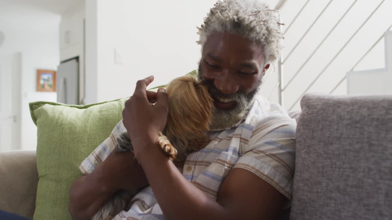 Homme senior jouant avec son chien à la maison