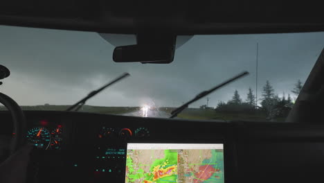 storm chasers driving through heavy rain with on coming vehicle head lights