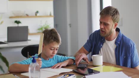 hombre caucásico ayudando a su hijo con la tarea