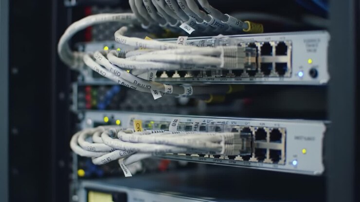 Close-up view of network switches in a data center filled with various cables and connectors, highlighting the complexity of digital communication technology in action.