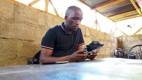 an african drone pilot flying drone in rural africa