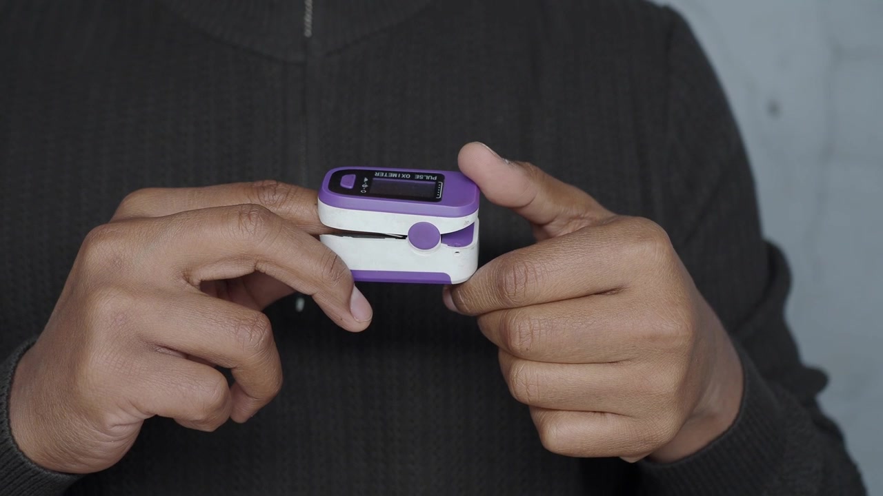 Person Using a Digital Fingertip Pulse Oximeter