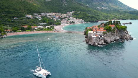 aerial landscape of sveti stefan, montenegro. tourist boat passing. famous and luxury travel destination. static footage.