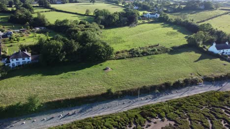 Luftbild-Roter-Strand-Pentraeth-Ackerland-Mit-Ferienhäusern-Entlang-Der-Salzwiesenpfanne-Links