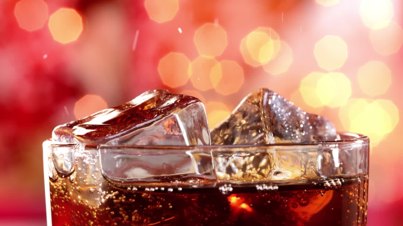 un vaso de cola. cola helada con burbujas salpicando cámara lenta en una luz borrosa, fondo borroso.