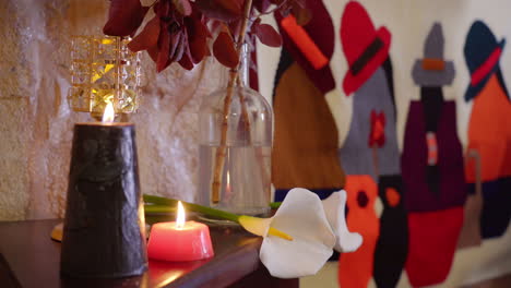 flores de lirio de calla en un ambiente relajante iluminado por velas, pared de piedra natural con decoraciones indígenas rústicas