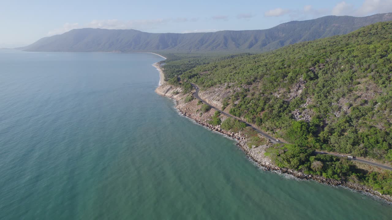 vehículos que circulan por la autopista captain cook a lo largo del mar de coral y el parque nacional macalister range en wangetti, australia