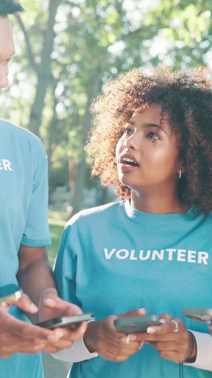 Happy Young Volunteers Using Smartphones Outdoors