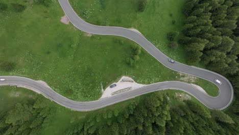 Perspectiva-Aérea-De-Los-Vehículos-Que-Navegan-Por-Las-Carreteras-Serpenteantes-Cerca-Del-Paso-De-Selva-En-Las-Montañas-Dolomitas,-Trentino,-Tirol-Del-Sur,-Italia