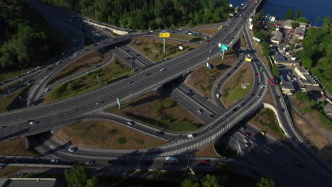 Highway-intersection-on-river-landscape.-Aerial-view-car-driving-on-freeway