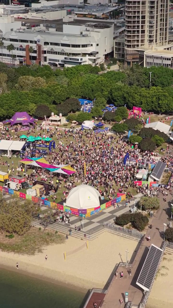 Vertical aerial footage trucking slowly left while panning right above the Gold Coast Marathon event precinct in Southport, Queensland, Australia