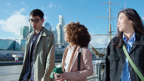 group of young business people walking on riverbank and having discussion