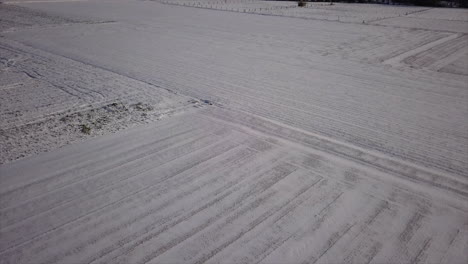 tilt-up-over-snow-covered-field-to-a-little-town-in-winter