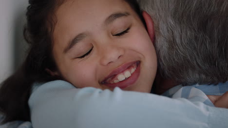 grandfather hugging granddaughter happy little girl embracing grandad enjoying affectionate hug from child sharing love gently holding grandparent at home