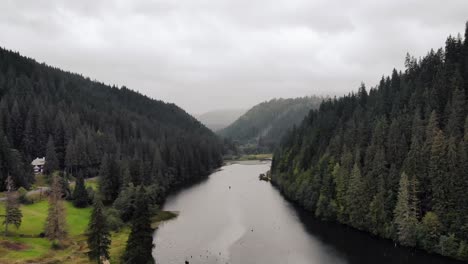 Aerial-Panorama-Of-A-Natural-Dam-Lake-Of-Lacu-Rosu,-Red-Lake-In-Carpathian-Mountains,-Moldavia-Region,-Romania