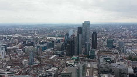 Slow-flight-above-large-town.-Aerial-view-of-downtown-with-group-of-modern-skyscrapers-in-City-financial-hub.-London,-UK