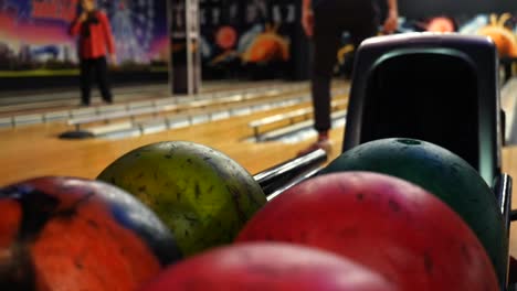 bolera con gente y bolas de bolos de colores