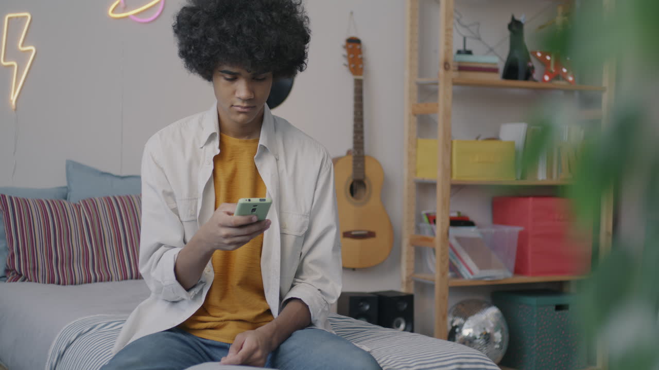 Teenager using smartphone in bedroom