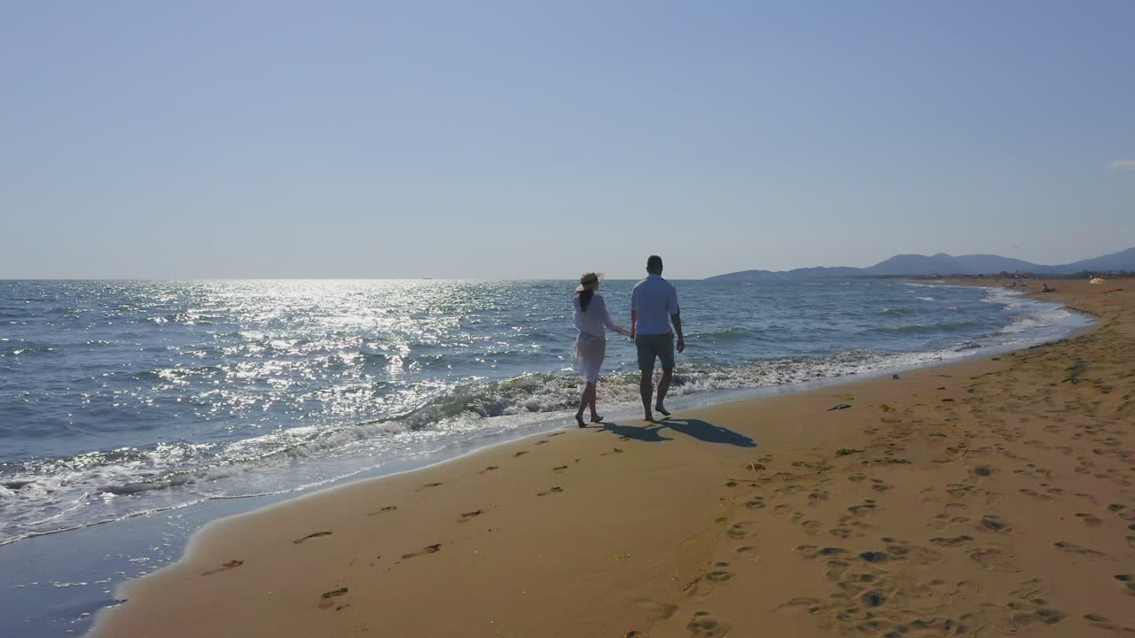 Una pareja caminando por la playa.