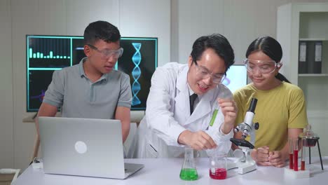 young asian boy and girl exciting while learning science experiment in laboratory with teacher in classroom. study with scientific equipment and tubes