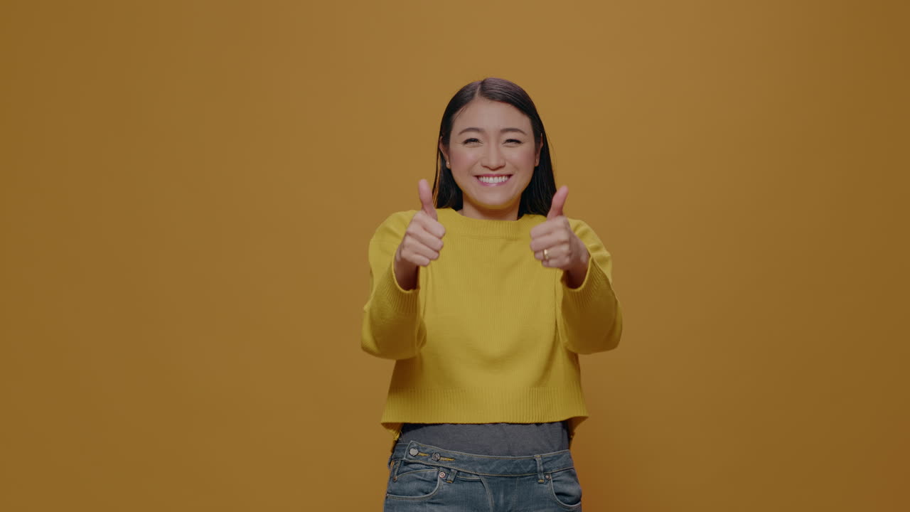 Cheerful person doing thumbs up gesture in front of camera