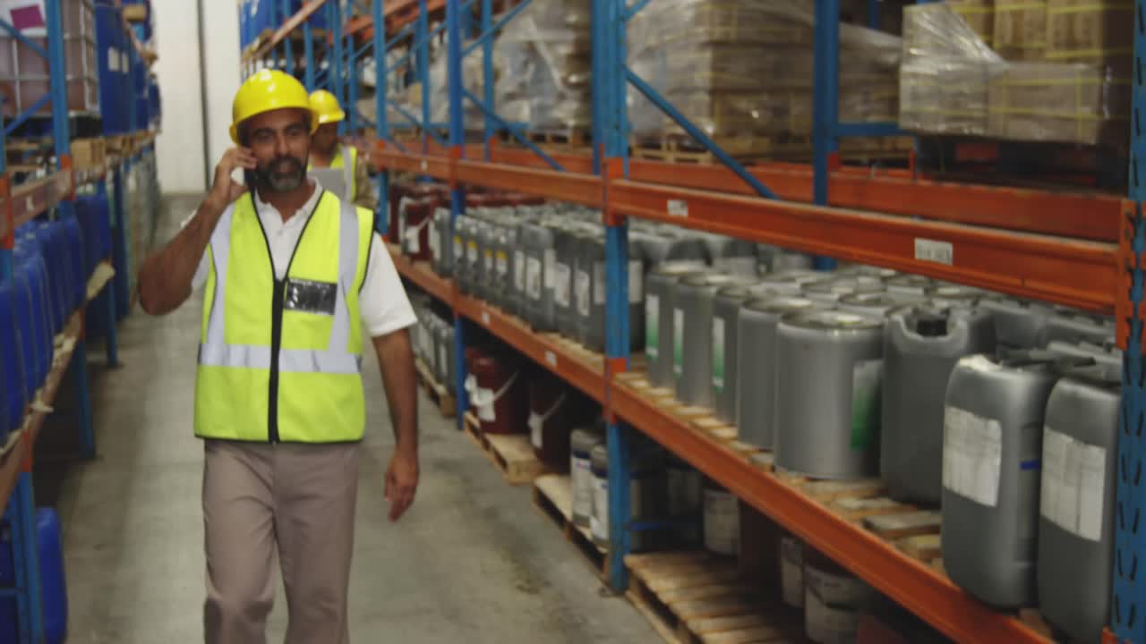 Male worker using smartphone in a warehouse