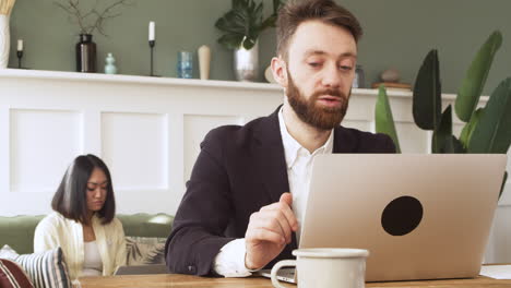 geschäftsmann, der am tisch sitzt und einen videoanruf auf einem laptop hat