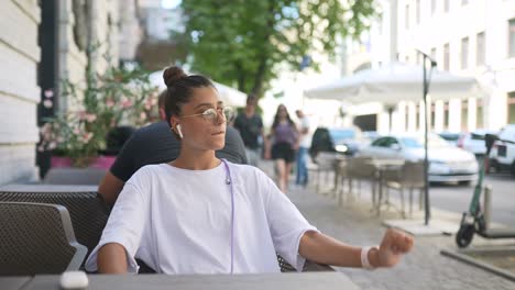 una mujer joven relajándose en un café al aire libre.