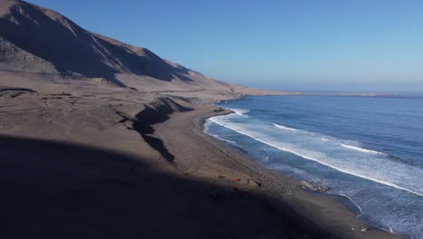 arid sandy landscape as desert mountains meet ocean coast in chile