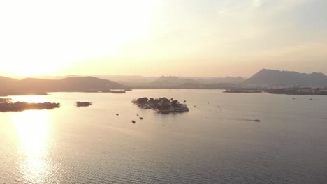 Imágenes-Aéreas-De-Drones-De-4k-Del-Palacio-Del-Lago-Taj-Del-Lago-Pichola-Al-Amanecer-Junto-A-La-Costa-De-La-Ciudad-De-Udaipur,-India