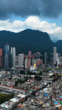 vertical drone shot toward the downtown of bogota city, cloudy day in colombia
