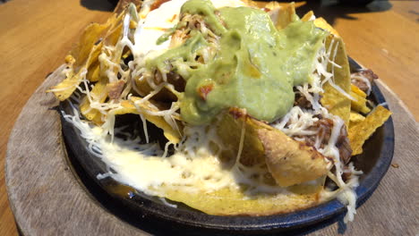 sharing a plate of tacos with guacamole and cheese