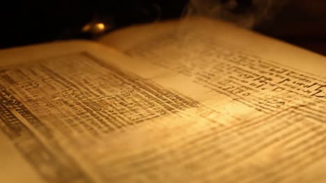 close up of an old book burning with flames and smoke