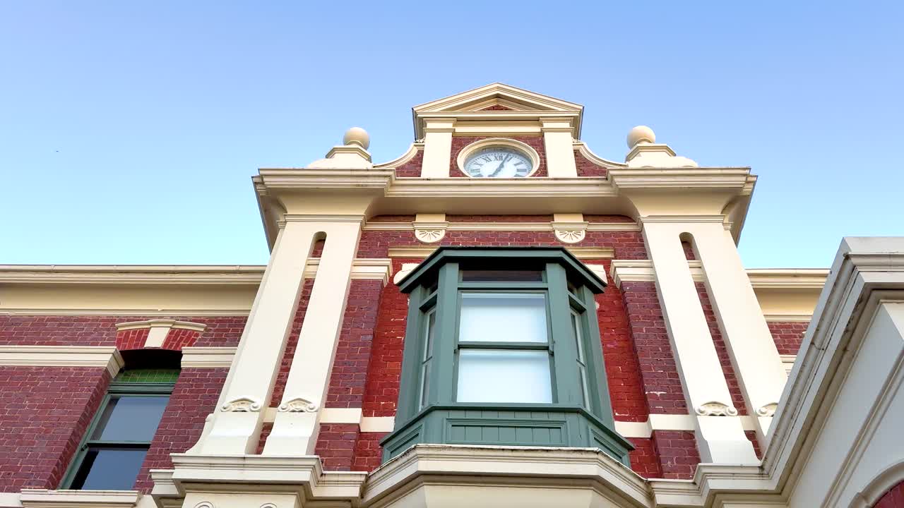 A series of frames showing the ornate clock tower of Queenscliff Post Office against a clear blue sky