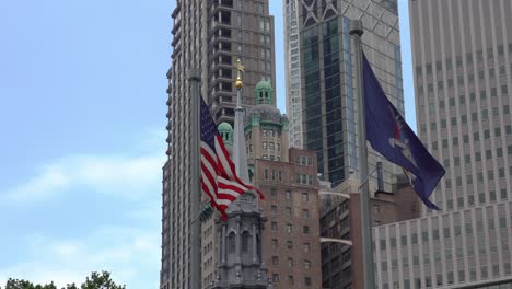 bandera estadounidense y la bandera del estado de nueva york contra un fondo del horizonte de nueva york