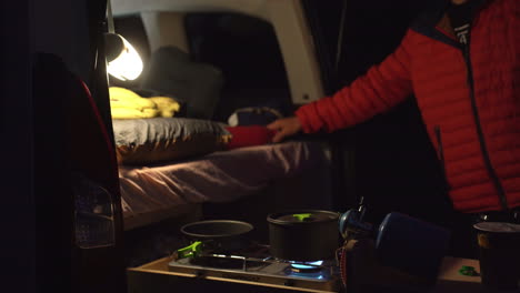 van life at night cocking food in camping car illuminated