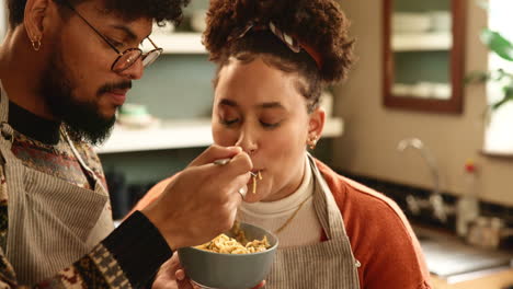 pareja alimentándose el uno al otro en la cocina