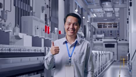 shot captures of an asian male professional worker standing at pharmaceutical factory, vaccine production facility, his broad smile at the camera and thumbs up