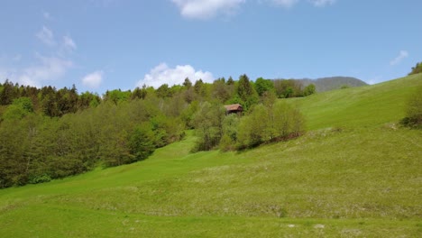 flying over green spring meadows in front of old hay barn