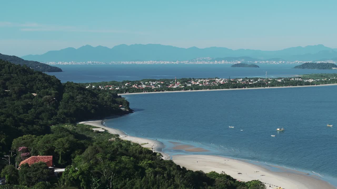 una imagen aérea giratoria captura la pintoresca playa de forte con la playa de daniela en el fondo