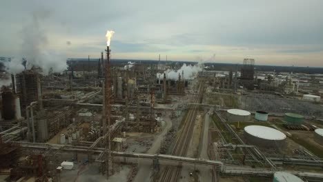 excellent aerial over huge industrial oil refinery with gas torch burning