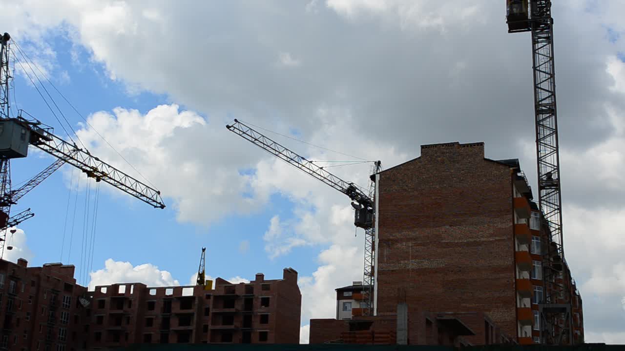 Construction cranes over houses. Construction of residential buildings