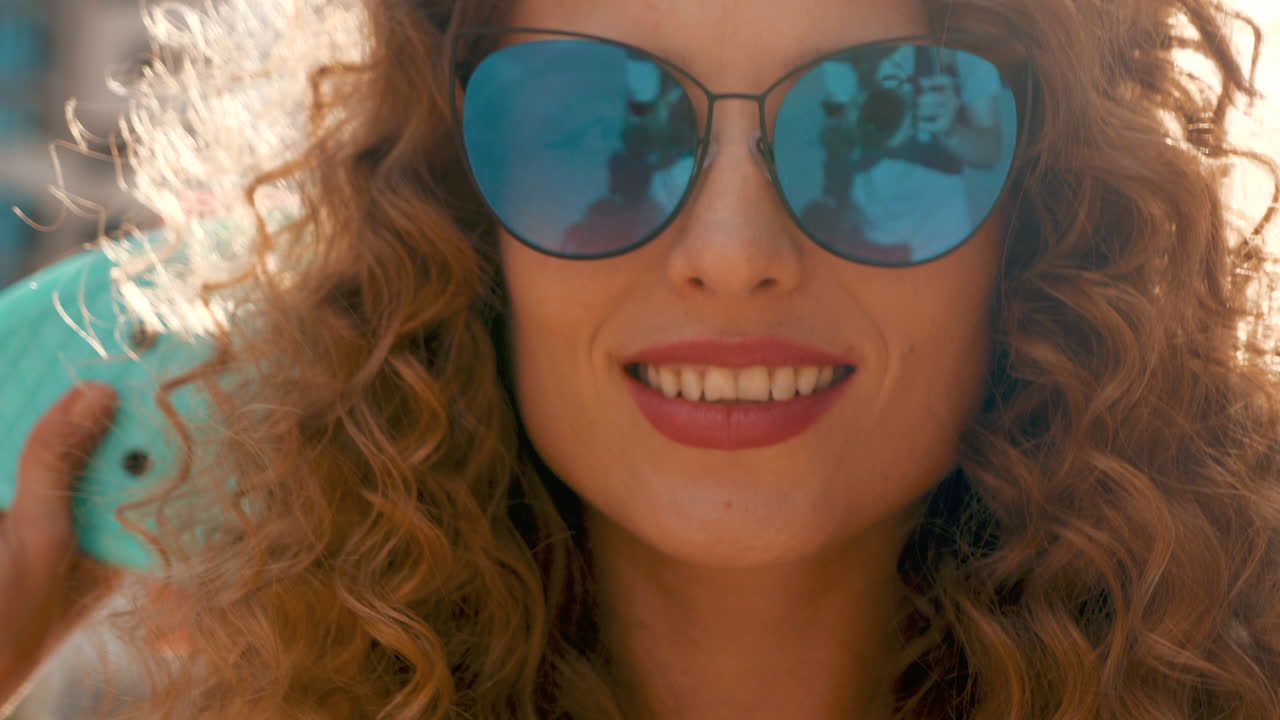 Una mujer con el cabello rizado sonriendo.