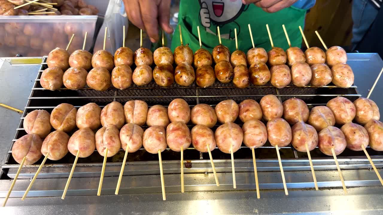 판매자 는 떠다니는 시장 의 상점 에서 소시지 를 고 있다