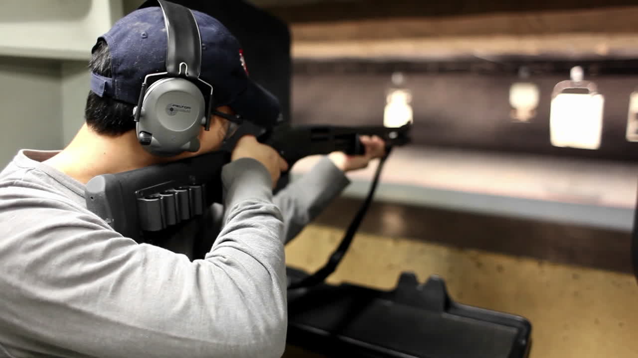 un hombre dispara un rifle a un objetivo en un campo de tiro interior 1